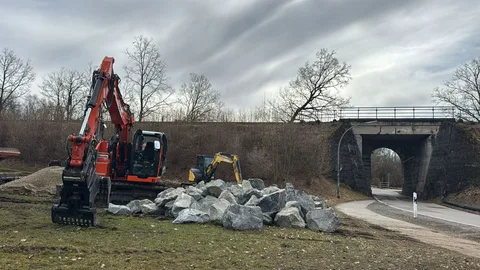 Rückbau an einer Böschung mit Natursteinen nahe einer Brücke