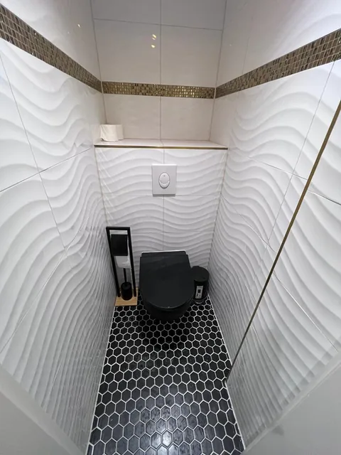 Gäste-WC nachher: fertiges WC mit Strukturfliesen, Mosaikband und schwarzem Sechseckboden