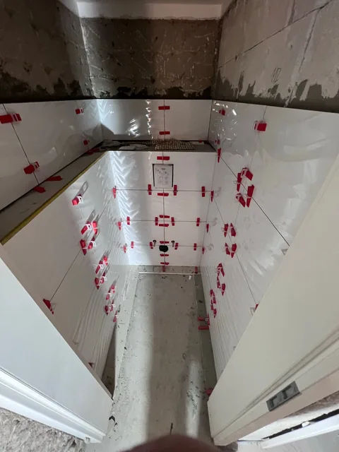 Gäste-WC vorher: frisch verlegte weiße Wandfliesen mit Nivelliersystem