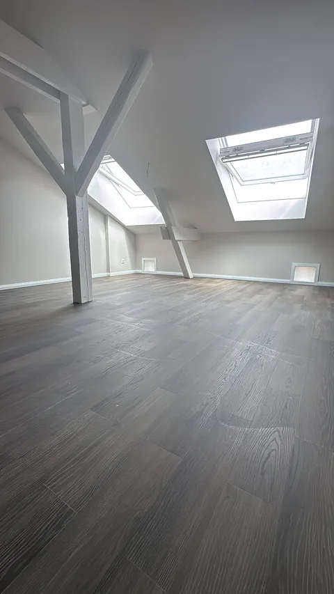 Dachgeschoss nachher: ausgebauter Raum mit Dachfenstern und Fußboden